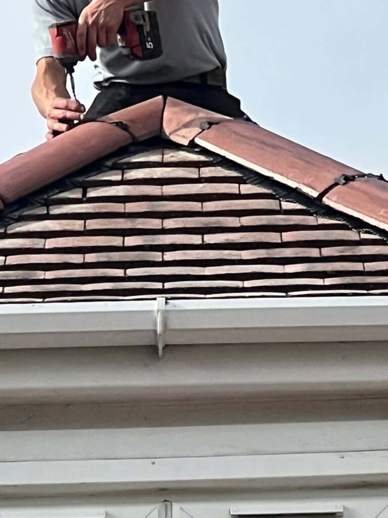 This is a photo of one of the operatives of MCM Roofing Repairs Salisbury installing new ridge tiles