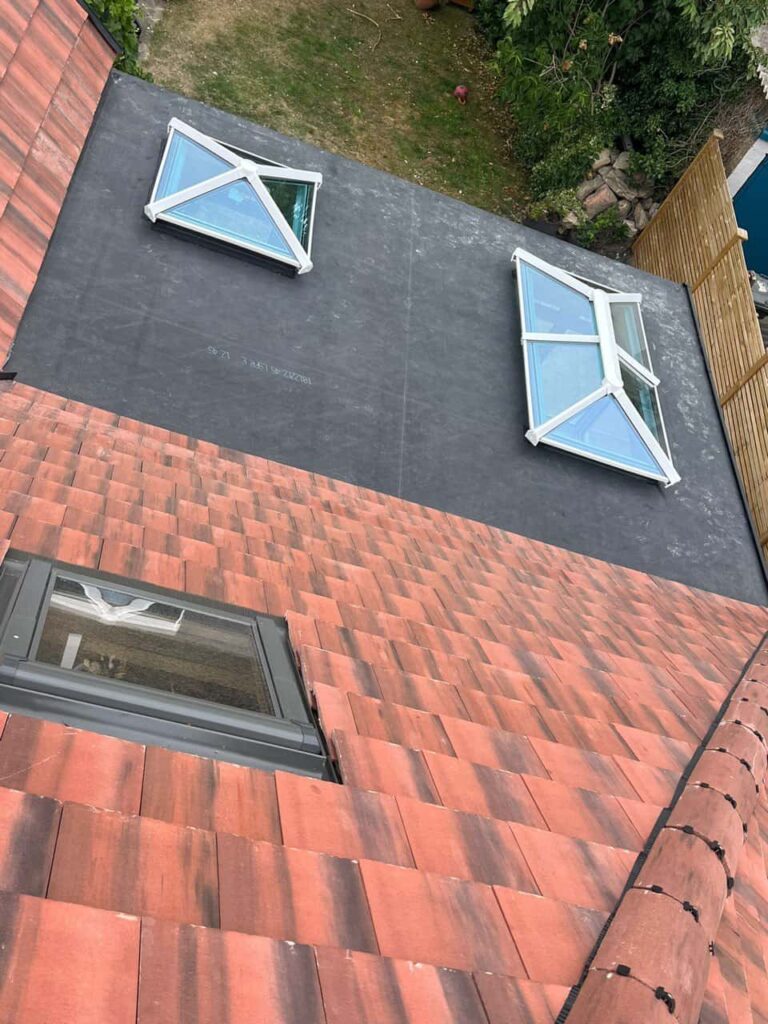 This is a photo taken from the roof ridge looking down a tiled pitched roof on to a flat roof. Works carried out by MCM Roofing Repairs Salisbury